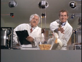 At his workplace, Albert (Dean Jones, right) tries to encourage a dim-witted duck to pass one of Dr. Gottlieb's tests.