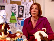 Samara McAdam speaks among puppets and sketches representing her wardrobe department's contributions to the special.