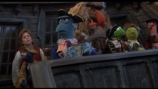 Jim Hawkins (Kevin Bishop) and assorted Muppets stand on the Hispaniola for roll call with Mr. Arrow (Sam the Eagle).