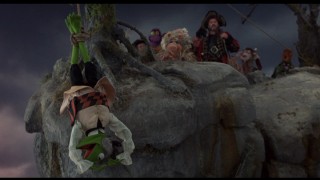 Kermit gets hung upside-down from the edge of a cliff. It'd be cooler without the inevitable Piggy/Kermit upside-down love ballad.