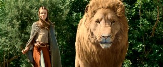 Lucy (Georgie Henley) and Aslan the Lion stand together at one end of a bridge.