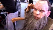 Having completed another day of work, Warwick Davis eagerly peels off his latex face mask.