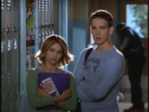 Lily and Harrison peer down fellow students in the hallway.