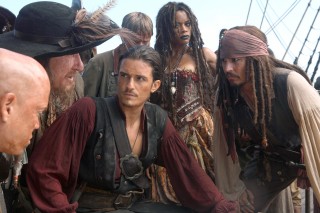 Will Turner (Orlando Bloom), Tia Dalma (Naomie Harris), and Captain Jack Sparrow (Johnny Depp) stop, collaborate, and listen, respectively.