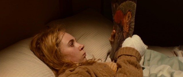 Insomniac Alicia (Juno Temple) finds a parrot photograph with an apology under her pillow in "Magic Magic."
