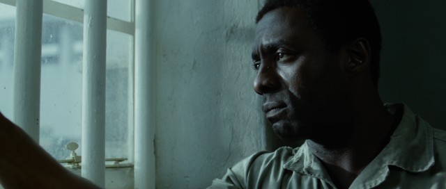 A glum Nelson Mandela (Idris Elba) looks out his jail cell's window in "Mandela: Long Walk to Freedom."