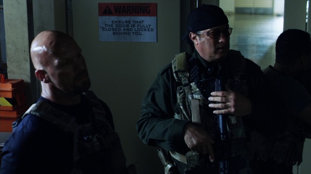 Sure, it's dark, but not too dark to make out Steve Austin and Steven Seagal joining forces to save the day. At least I think that what's happening.