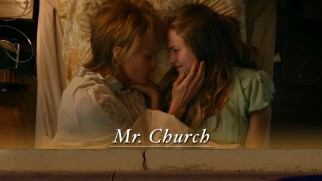 Mother (Natascha McElhone) and daughter (Britt Robertson) share a bed embrace on the Mr. Church Blu-ray menu.