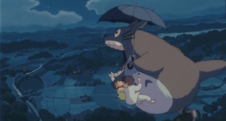 The big gray Totoro lets out a noise as he gives an umbrella ride to four small friends.