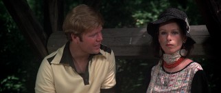 BBC reporter Opal (Geraldine Chaplin) soon grows tired of businessman Bud (Dave Peel) at a party attended by Elliott Gould.