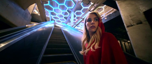 Emma Roberts play Venus Delmonico, who in this shot looks like Little Red Riding Hoodie.