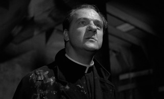 Father Pete Barry (Karl Malden) doesn't let falling alcohol or scowls deter his worksite preaching in the wake of a fatal "accident."