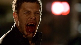 Klaus (Joseph Morgan) makes his best vampire face of bloody fangs.