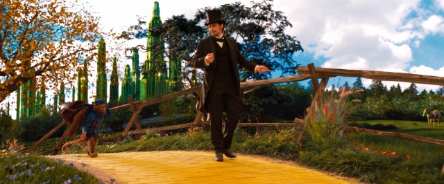 Finley the monkey carries Oz's bag as the two talk a stroll along the yellow brick road just outside the Emerald City.