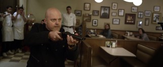 Derrick (Michael Chiklis) calls the shots with a loaded gun and a firm tone to his Cockney accent.