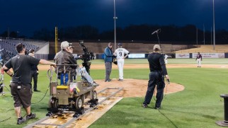 A behind-the-scenes gallery photo shows the filming of a baseball diamond scene.