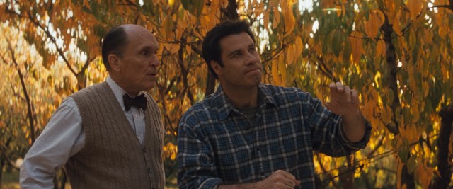 Doc Brunder (Robert Duvall) looks on, as George Malley (John Travolta) tries to feel his way to the missing sick boy in need of medical attention.