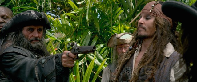 Blackbeard (Ian McShane) orders Captain Jack Sparrow (Johnny Depp) with a gun in his hand.