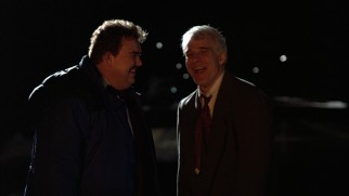 Del and Neal can only laugh and watch as their rented car goes up in flames.