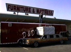 In character as the D & D mattress man, Philip Seymour Hoffman pitches mattresses and takes a fall off the stack of mattresses in this faux commercial.