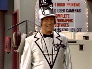 Behind a smile, Henry (George Gaynes) hides the pain of his new position as Glossy's manager.