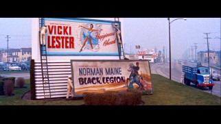 Norman Maine's movie billboard goes down and Vicki Lester's goes up. Screencap from 2010's Deluxe Edition DVD - click to view in full 720 x 480.