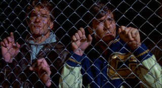 Brothers Jed (Patrick Swayze) and Matt Eckert (Charlie Sheen) are sad to find their hometown under siege and their father on the other side of this fence in Calumet's Drive-In Theater-turned-reeducation camp