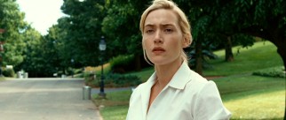 April (Kate Winslet) wears a contemplative expression as she looks down her suburban street.