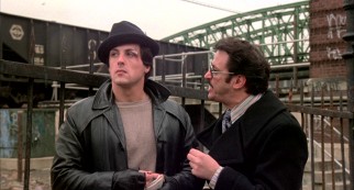 In the role that made him a star, screenwriter Sylvester Stallone portrays Rocky Balboa, a debt enforcer for loan shark Tony Gazzo (Joe Spinell).