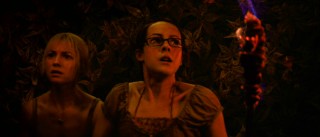 Leading ladies Stacy (Laura Ramsey) and Amy (Jena Malone) wield torch in a dark, red-tinted cave in a scene Benjamin Gates can appreciate.
