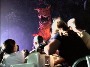 A big red dinosaur frightens park visitors on the thrilling Countdown to Extinction attraction.