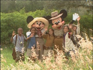 Decked out in their safari threads, Mickey, Minnie, and the cast of kids wave "jambo."