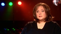 In front of a disco ball and colored lights, Donna Pescow (whom early 2000s Disney Channel viewers will recognize as the mom from "Even Stevens") is one of many cast members reflecting on their 1970s experiences in five "Catching the Fever" featurettes.
