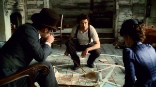 Holmes crouches and points out what he thinks he, Watson, and Adler are up against in the deadly satanic cult.