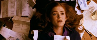 Becky (Isla Fisher) lays down in a sea of a receipts and credit card statements, as all credit card debt victims do.