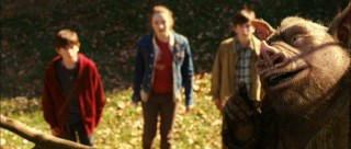 The three Grace children are all ears as Hogsqueal the uncouth hobgoblin (voiced by Seth Rogen) imparts some wisdom on them.