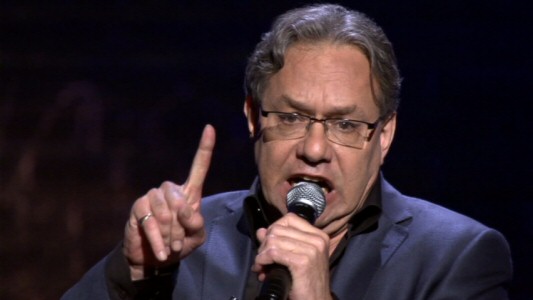 Lewis Black puts his famously defiant finger in the air while charging through another uproarious rant.