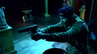 "British" Major Peatman (Brent Stait) decides a "New York" archaeological museum gallery is as good a place as any to draw his weapon.
