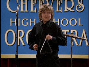 Zack (Dylan Sprouse) shows off his musical "talent" by playing the triangle in the Cheevers High School Orchestra.