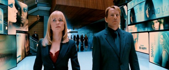 Agents Peters (Radha Mitchell) and Greer (Bruce Willis) take a purposeful stroll through surrogate manufacturer Virtual Self Industries' sleek lobby in Jonathan Mostow's "Surrogates."