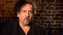 Director Tim Burton speaks in front of fence and brick in "The Making of 'Sweeney Todd...'."