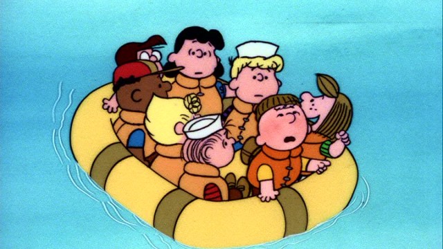 Eight members of the Peanuts gang share a raft in the camp movie "Race for Your Life, Charlie Brown."