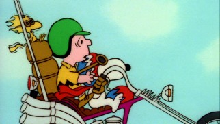 Charlie Brown gets a motorcycle ride to Camp Remote courtesy of Snoopy and Woodstock.