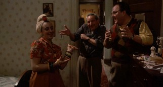 Cousin Ruthie (Joy Newman) entertains herself and her relatives (Michael Tucker and Josh Mostel) with a costumed lip-synching of Carmen Miranda.