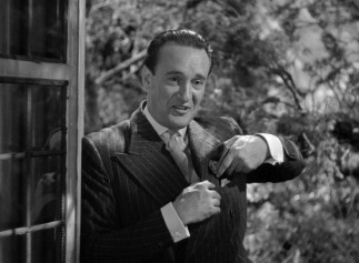 Smarmy Jack Favell (George Sanders), Rebecca's "favorite cousin", appears outside one of Manderley's windows.