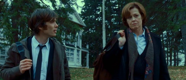 Doctors Buckley (Cillian Murphy) and Matheson (Sigourney Weaver) walk calmly from a house, another haunting debunked.
