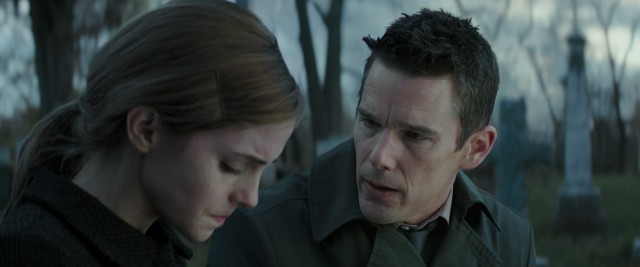 Detective Bruce Kenner (Ethan Hawke) consoles Angela Gray (Emma Watson) by the grave of her mother.