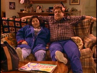 Roseanne (Roseanne Barr) and Dan (John Goodman) share a rare relaxing moment together.