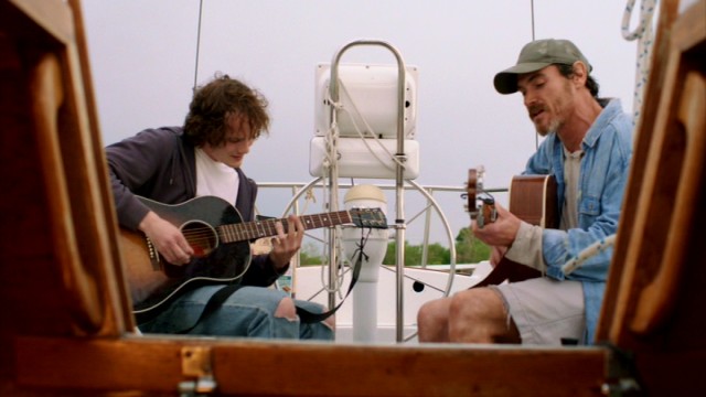 Invited on to the houseboat, Quentin (Anton Yelchin) jams with Sam (Billy Crudup).