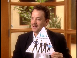 Tom Hanks fondly recalls The Rutles' triangular album, which he holds up in "Can't Buy Me Lunch."